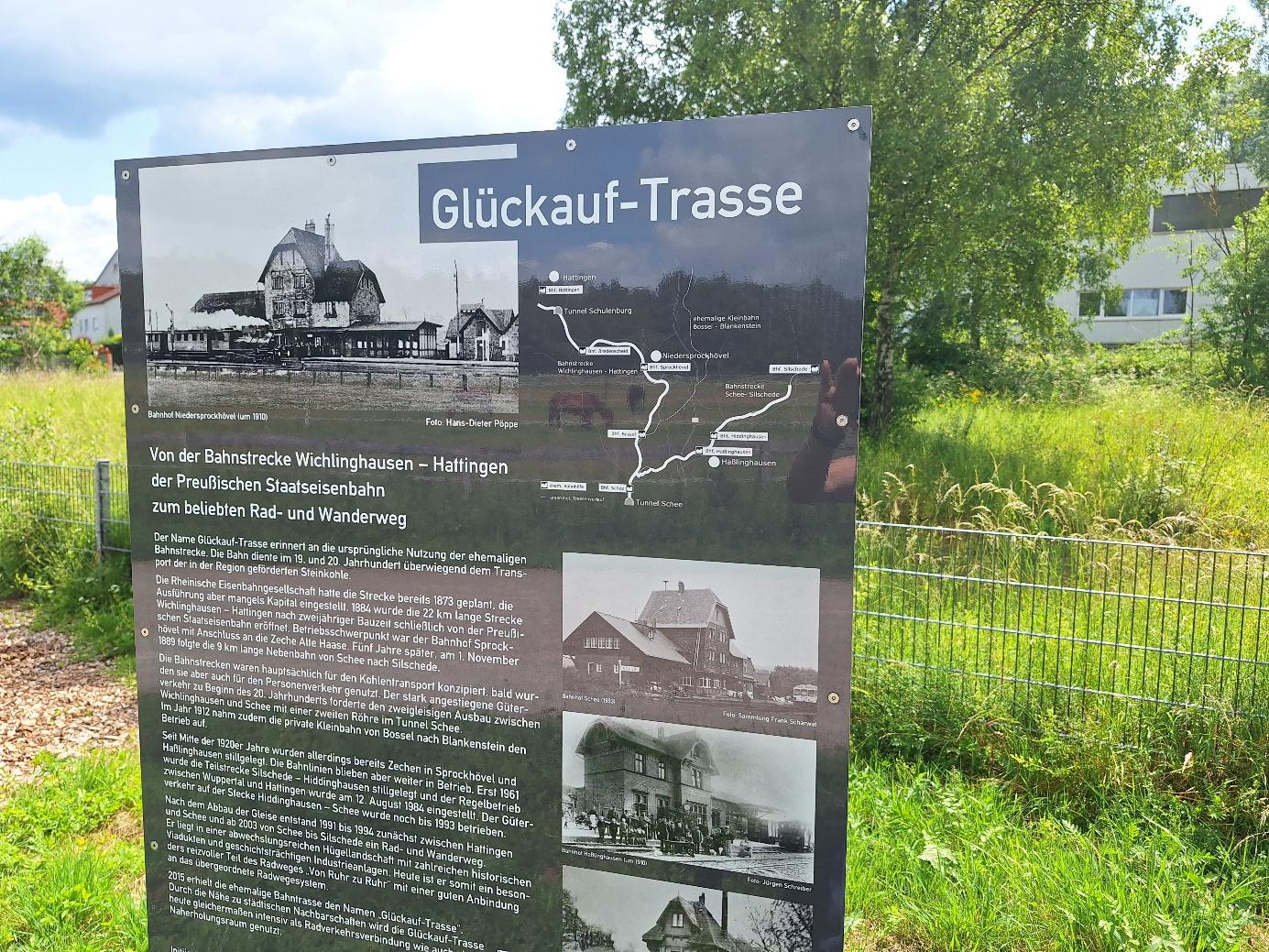 Infotafel zur Geschichte der Glückauftrasse neben dem Rad- und Fußweg mit Schwarzweiß-Fotos.