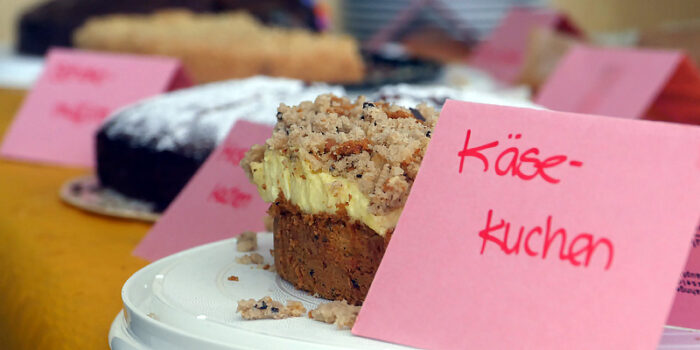 Verschiedene Kuchen stehen auf einem Tisch, dazu ein Schild mit der Aufschrift Käsekuchen